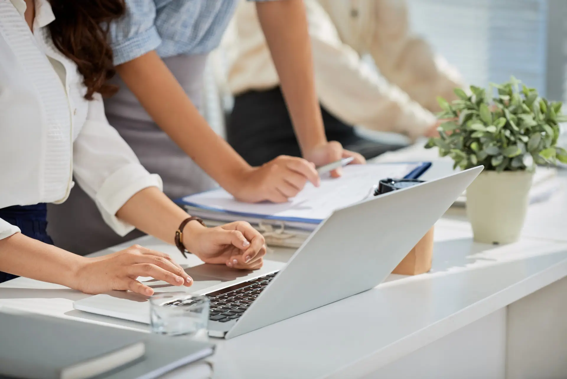 Personas trabajando con ordenador y documentación inmobiliaria