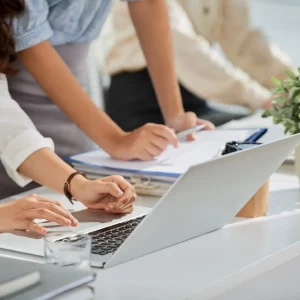 Personas trabajando con ordenador y documentación inmobiliaria